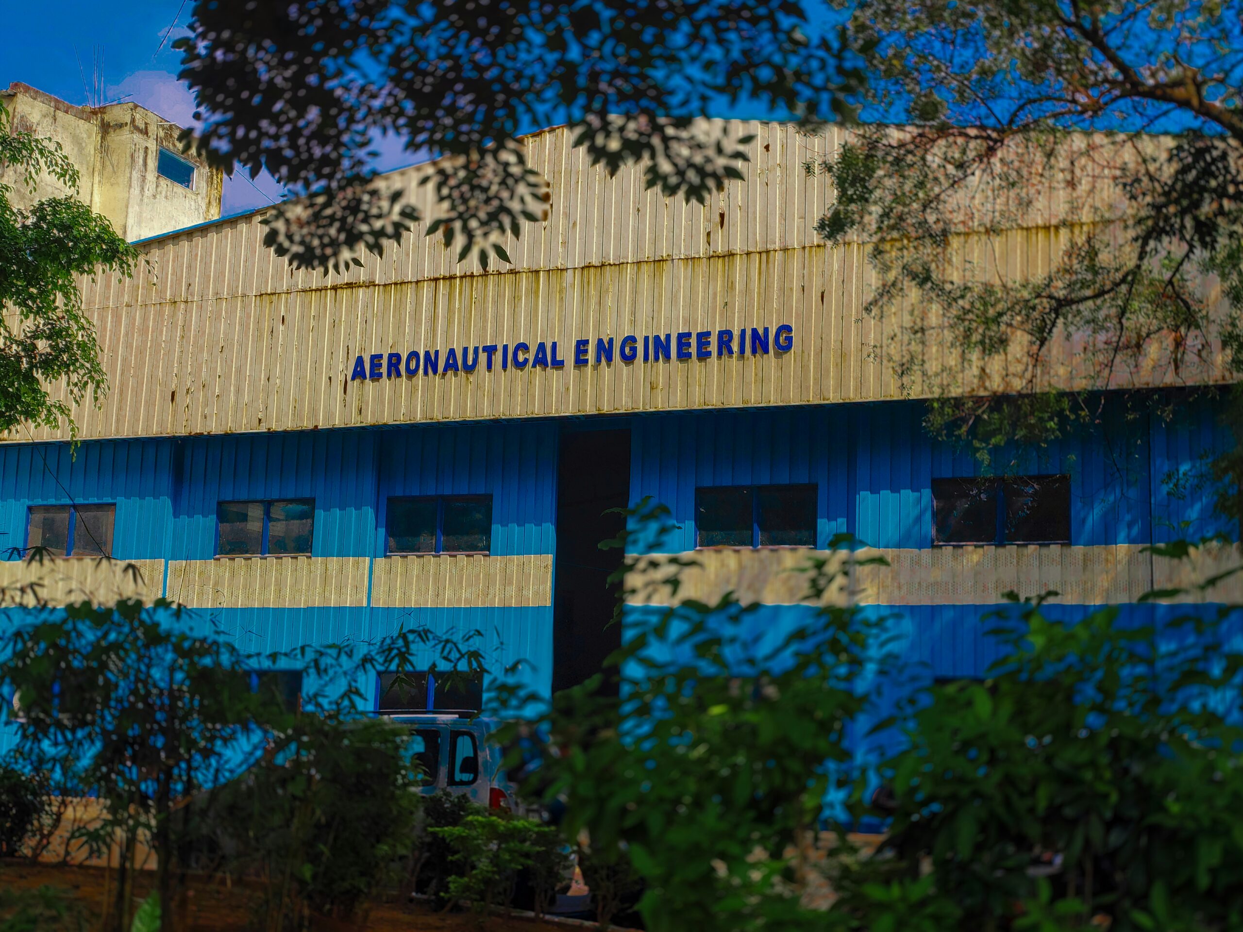 a blue and yellow building with trees in front of it